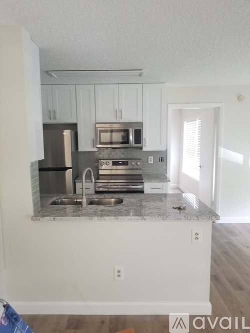 A kitchen with white cabinets and a granite countertop.