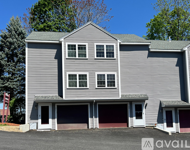 A house with a grey siding and two garages.