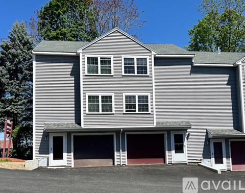 A house with a grey siding and two garages.
