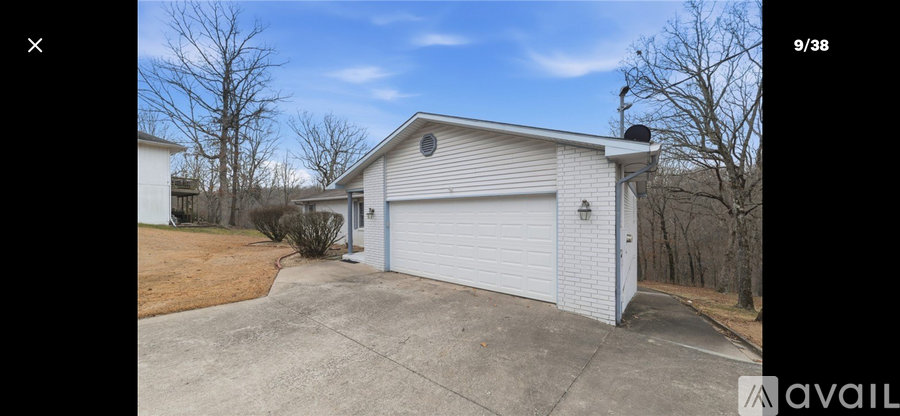 A detached garage with a white door and a brown driveway.