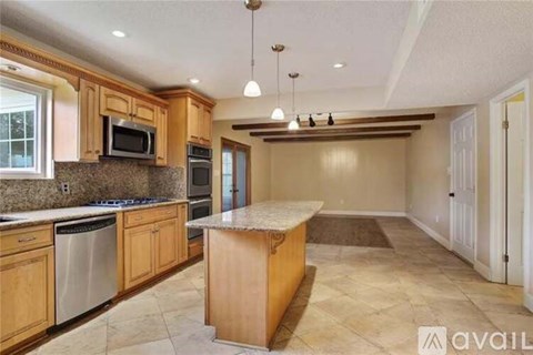 A kitchen with wooden cabinets and a granite countertop.