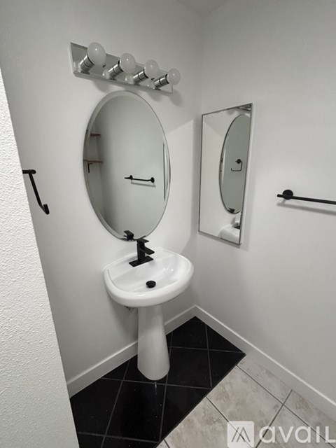 A white sink with a round mirror above it.