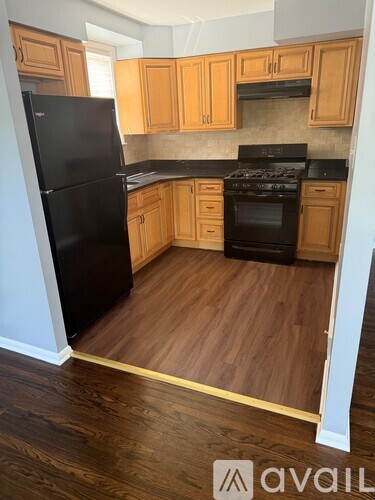 A kitchen with wooden cabinets and black appliances.