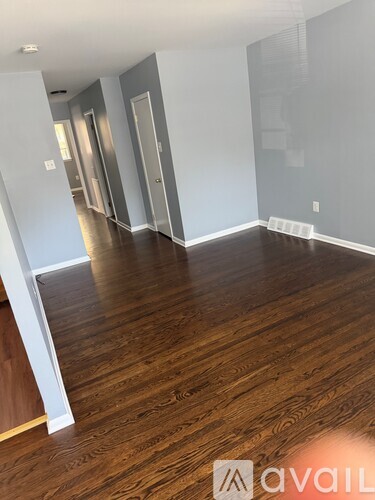 A room with wooden flooring and white walls.