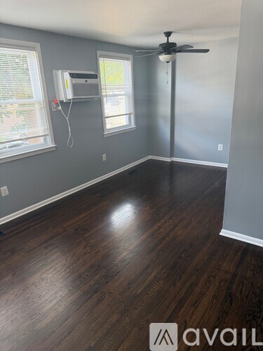 A room with a fan and a window with blinds.