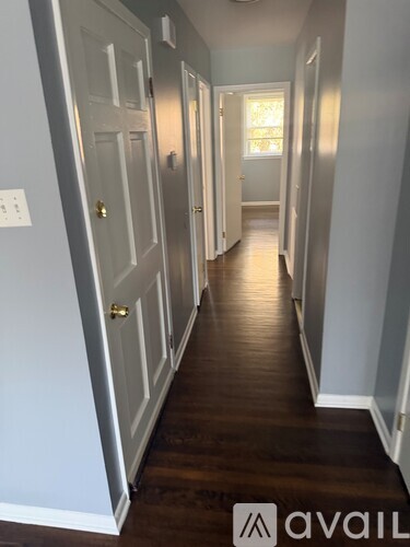 A hallway with wood floors and white walls.