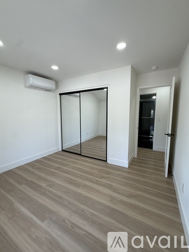 A room with a sliding door and wooden flooring.