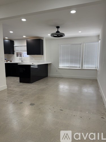 A modern kitchen with black cabinets and a large island.