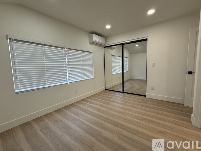 A room with a sliding door and a window with blinds.