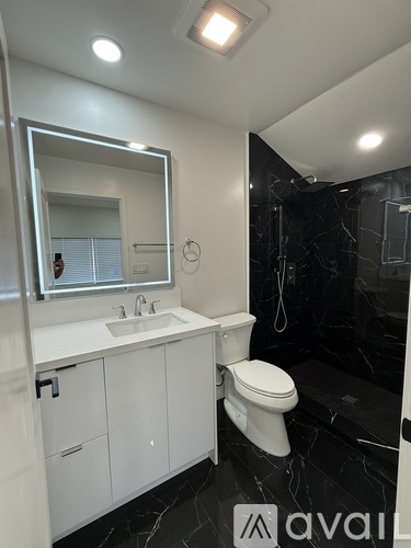 A bathroom with a white sink and toilet.