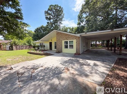 A house with a driveway and trees in the background.
