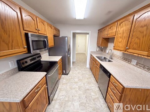 A kitchen with wooden cabinets and black appliances.