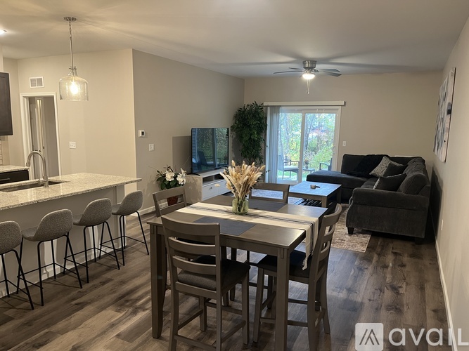 A dining room with a table set for six and a couch.