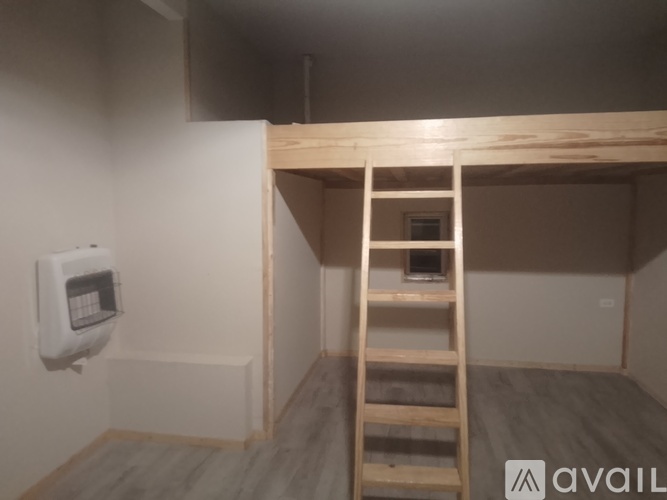 A wooden ladder is leaning against a wall in a room with a white radiator on the wall.