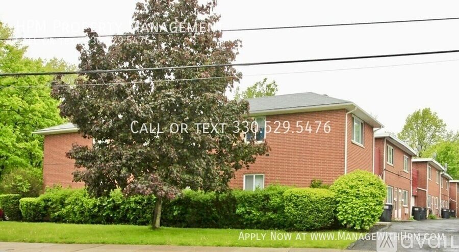 A house with a tree in front and a sign that says "Call or Text 302.529.5476".