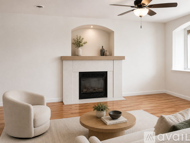 A living room with a fireplace, a chair, a table, and a ceiling fan.