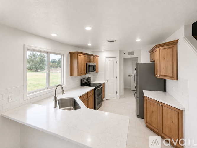 A kitchen with white countertops and wooden cabinets.