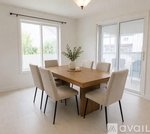 A dining room with a wooden table and chairs.