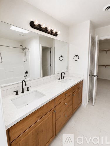 A bathroom with a white countertop and wooden cabinets.