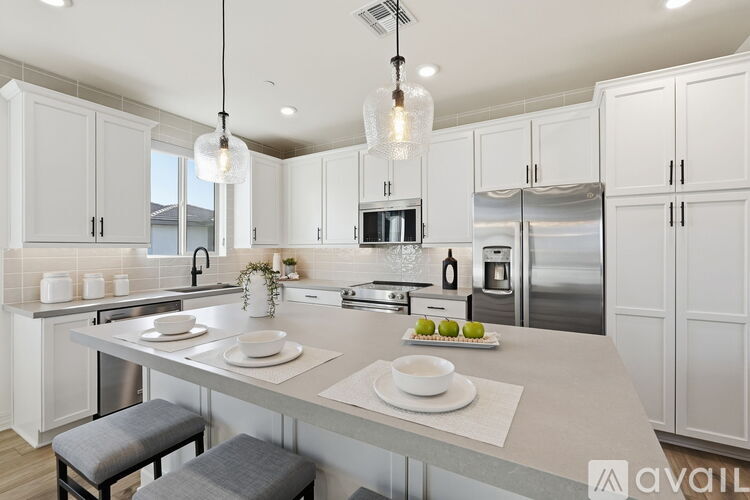 A modern kitchen with white cabinets and a center island.