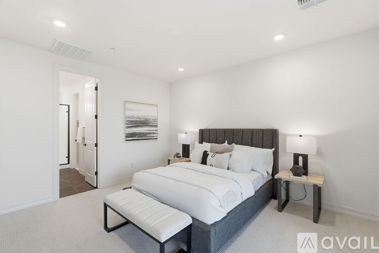 A bedroom with a large bed and a bench in front of it.