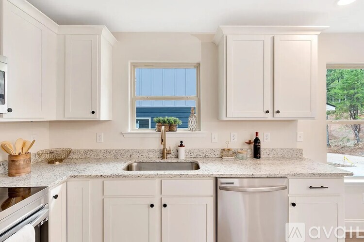 A kitchen with white cabinets and a granite countertop.