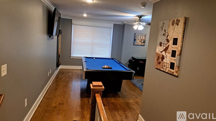 A room with a pool table and a television.