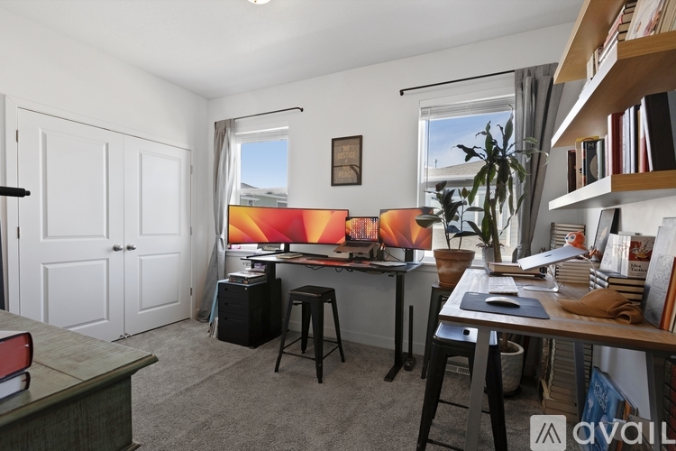 A room with a desk, chair, and a bookshelf.