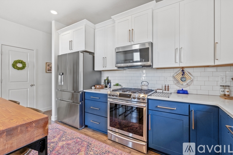 A kitchen with blue cabinets and stainless steel appliances.