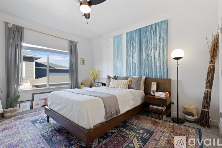 A bedroom with a large bed and a ceiling fan.