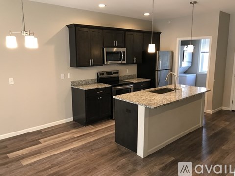 A kitchen with black cabinets and a granite countertop.