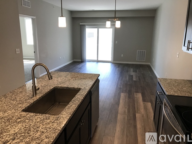 A kitchen with granite countertops and wooden floors.
