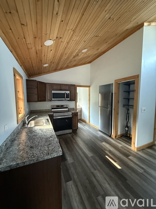 A kitchen with a granite countertop and wooden cabinets.