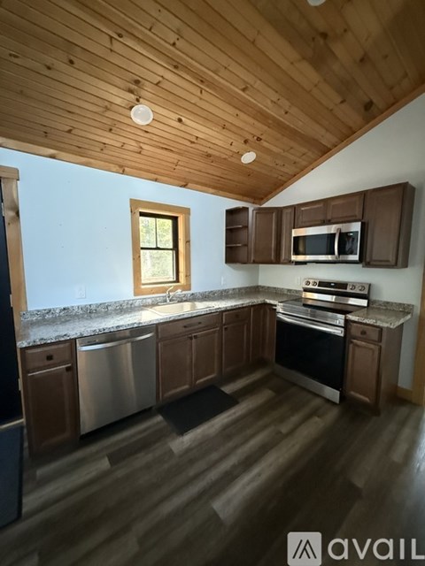 A kitchen with wooden cabinets and a window overlooking the ocean.