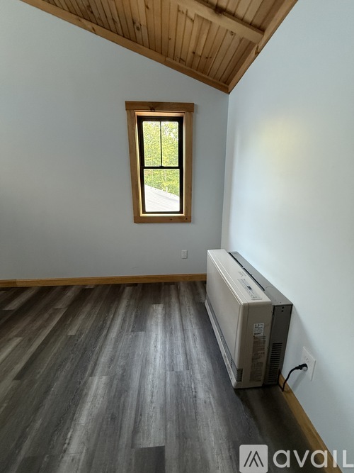 A room with a window and a wall-mounted air conditioner unit.