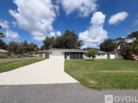 A house with a driveway and a grassy area in front.