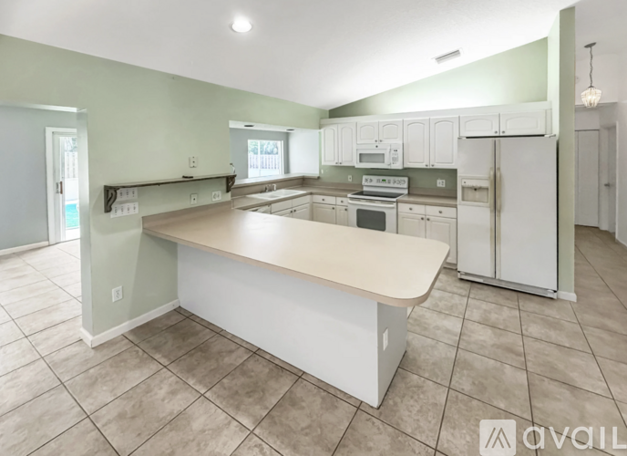 A kitchen with a white island in the middle of it.