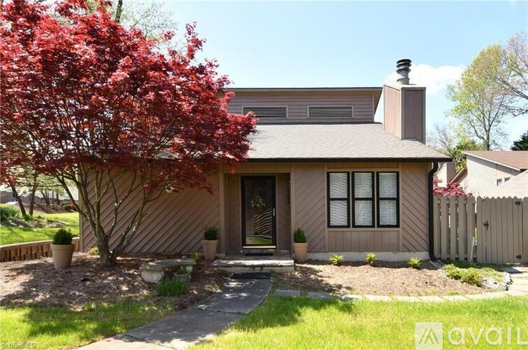A house with a red tree in front of it.