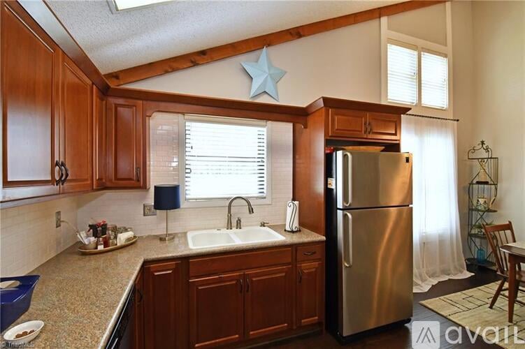 A kitchen with wooden cabinets and a stainless steel refrigerator.