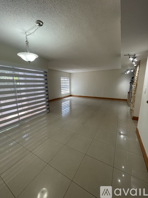 A hallway with wooden doors and a stone wall on the left.
