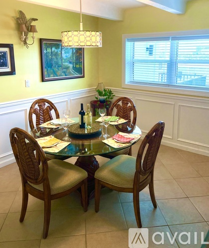 A dining table with chairs and a potted plant.