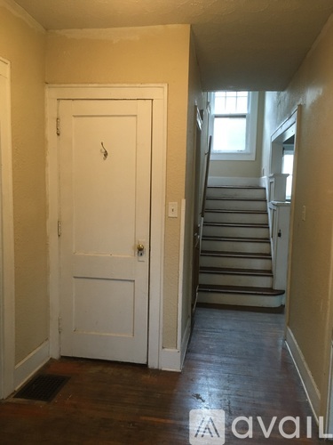 A white door with a keyhole is in a room with a wooden floor.