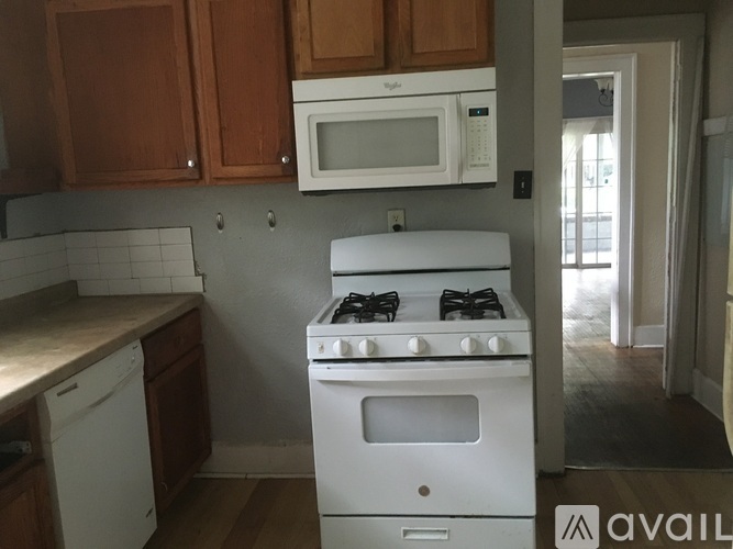 A white stove in a kitchen with wooden cabinets.