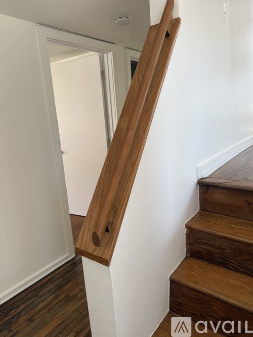 A wooden staircase with a white wall on the side.