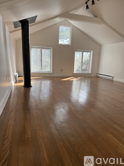A room with wooden floors and a large window.