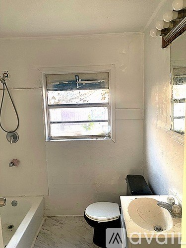 A bathroom with a toilet, sink, and tub.