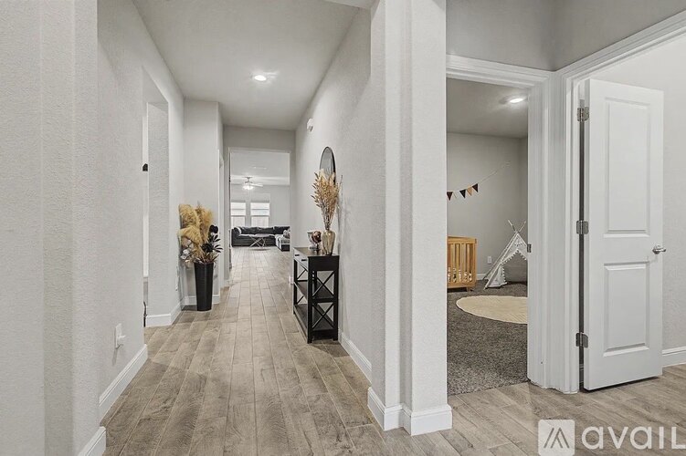 A hallway with a white door and a mirror on the wall.