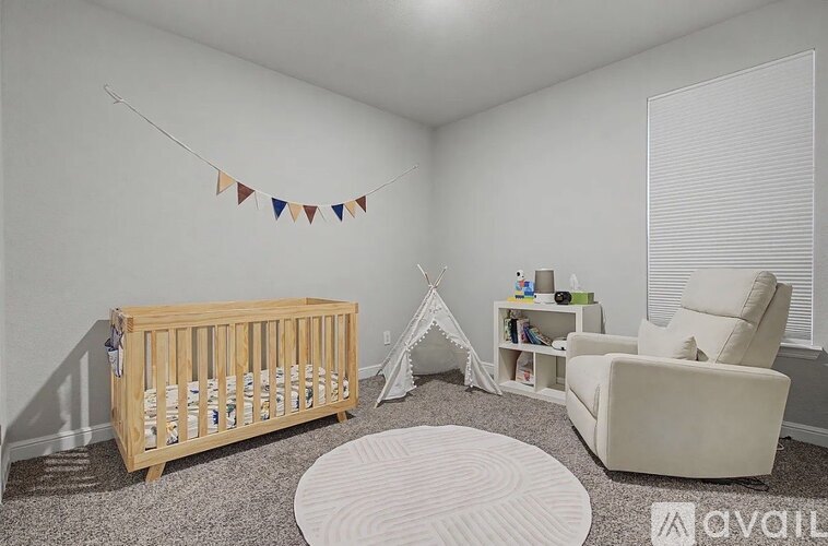 A baby's room with a crib, a chair, and a teepee.