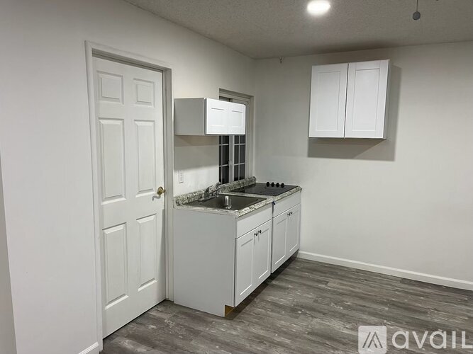 A kitchen with white cabinets and a sink.