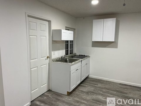 A kitchen with white cabinets and a sink.